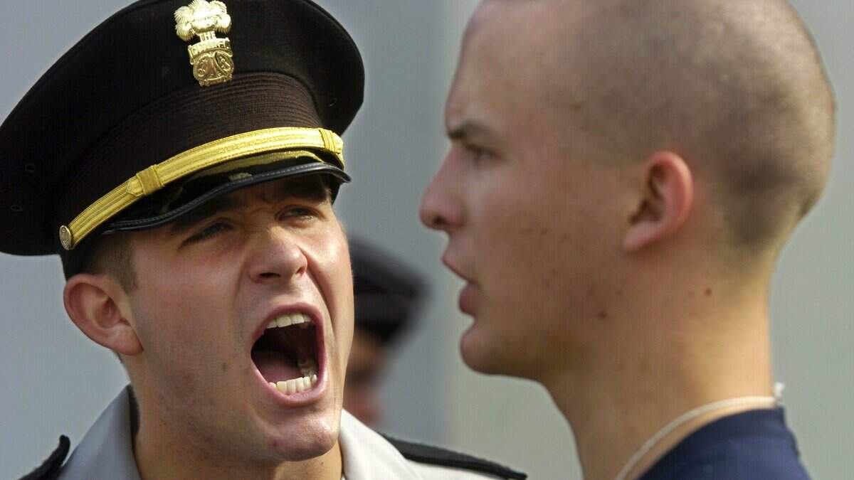 Cadre drill sergeant Rhett Cleveland, left, yells at incoming freshman Justin Kursh outside of the cadet bookstore during “Knob Day,” Tuesday, Aug. 17, 2004, at The Citadel in Charleston, S.C., which marks the first day of freshman orientation. (AP Photo/The Post And Courier, Grace Beahm)