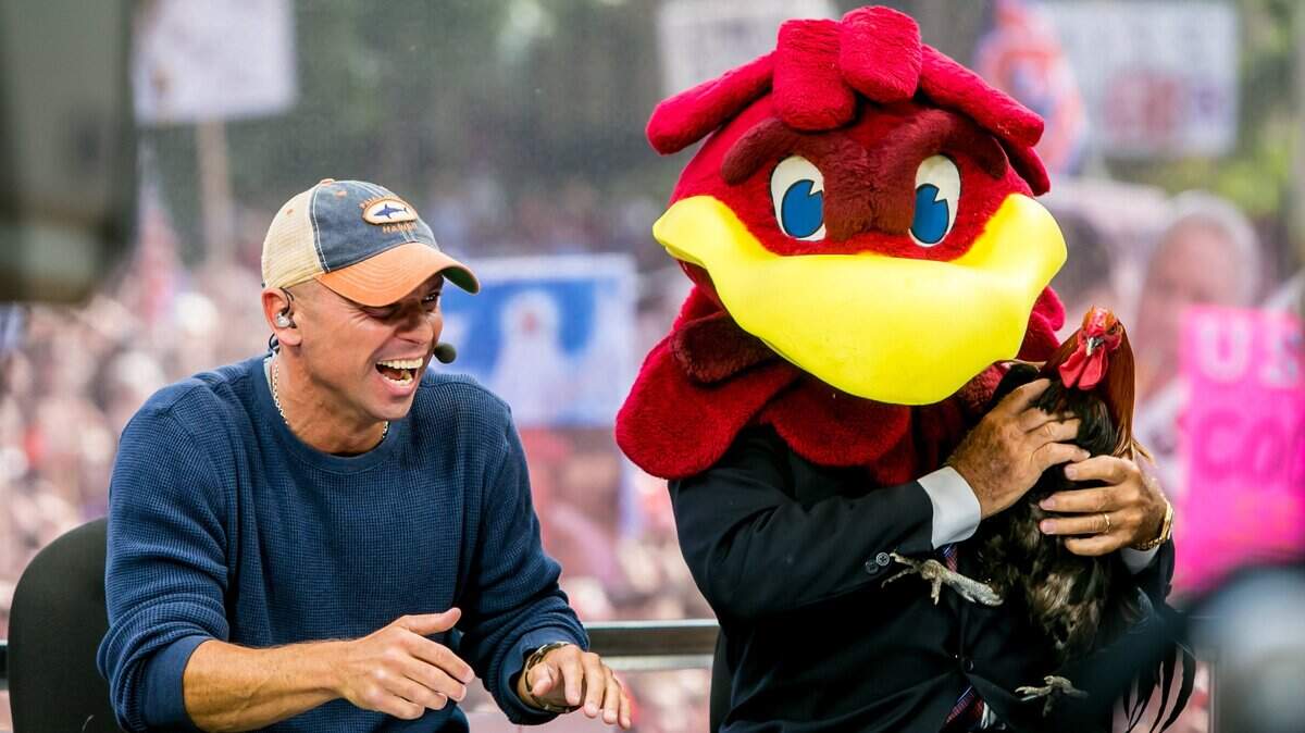 From 2014: With Kenny Chesney looking on, Lee Corso dons the Gamecock headpiece and holds Sir Big Spur, signifying his picking of South Carolina to win over Missouri, during ESPN’s College GameDay broadcast from the University of South Carolina’s Horseshoe.