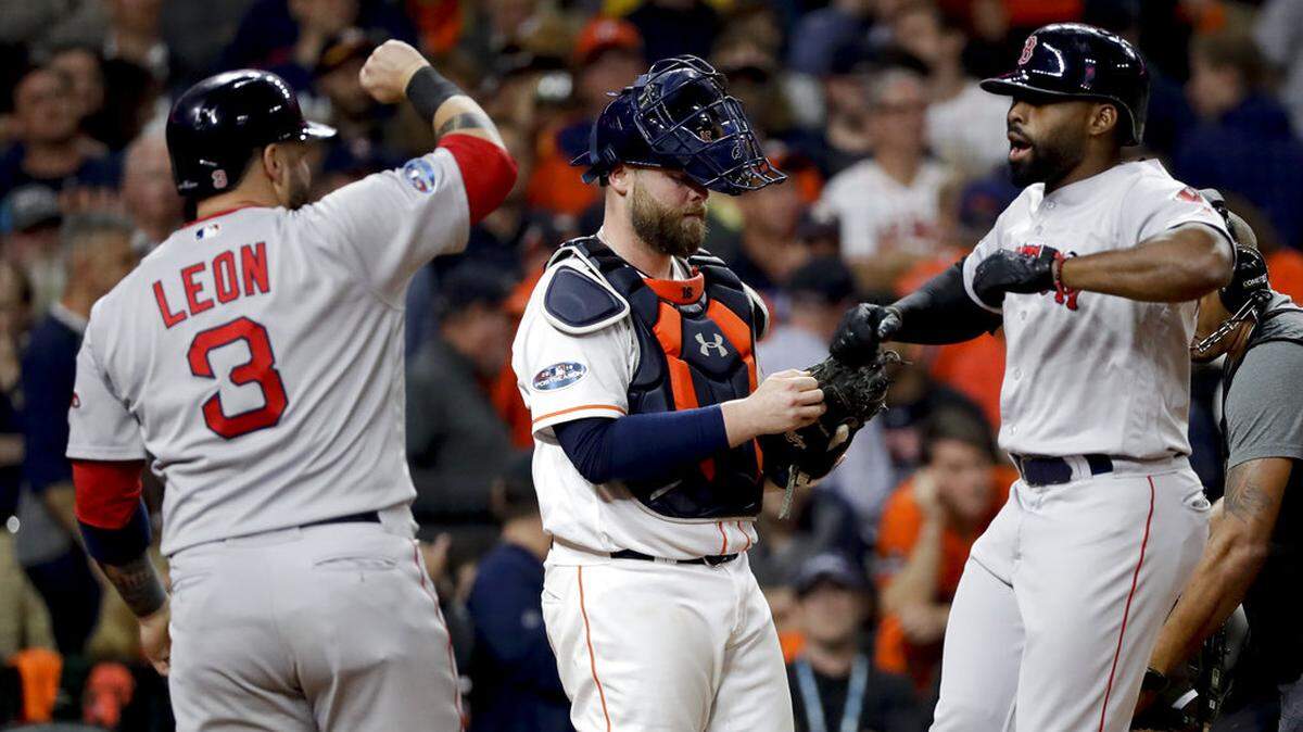 Boston Red Sox’s Bradley Jr., right, celebrates after watches his grand slam with Sandy Leon, left, against the Houston Astros during the eighth inning in Game 3 of a baseball American League Championship Series on Tuesday, Oct. 16, 2018, in Houston.