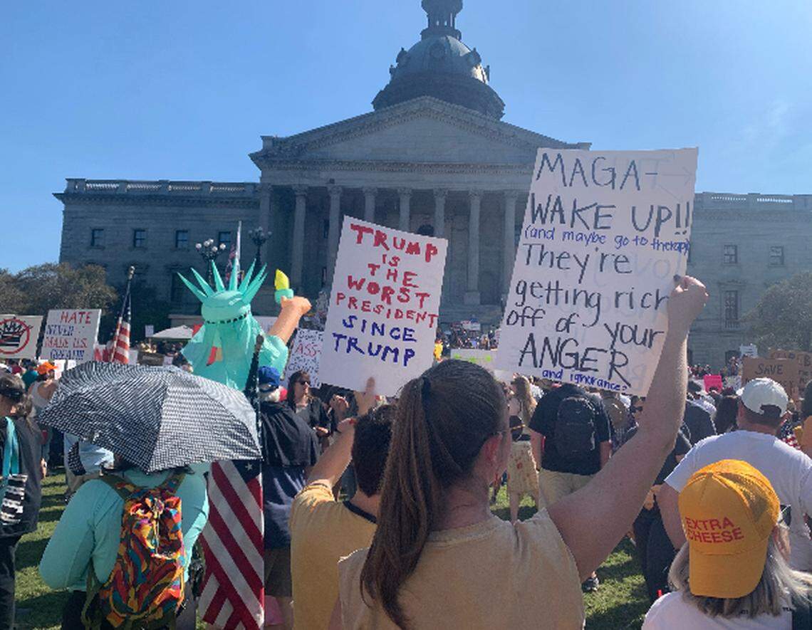 Protesters wave signs at the ‘No Kings’ rally in Columbia, Saturday October 18, 2025. The rally was among multiple protests nationally over President Donald Trump’s policies.