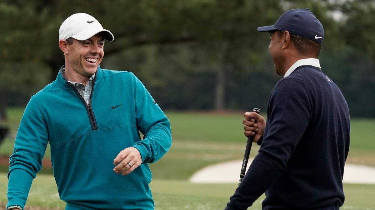 Tiger Woods is greeted by Rory McIlroy, of Northern Ireland during a practice round for the Masters golf tournament on Tuesday, April 5, 2022, in Augusta, Ga. (AP Photo/Charlie Riedel)