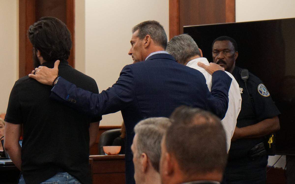 Columbia attorney Eric Bland comforts Greg Leon and his son Greg Leon IV, while the younger Leon asked Judge Walton J. McLeod to consider a minimum sentence for his father on July 6, 2023.