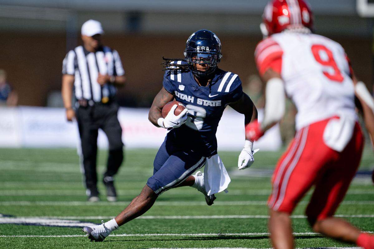 Utah State Aggies running back Rahsul Faison (3) runs with the ball against the Utah Utes at Merlin Olsen Field at Maverik Stadium.