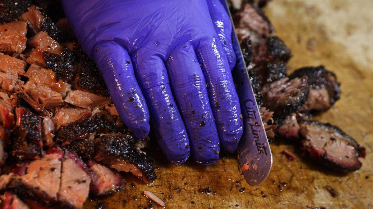Robbie Robinson, owner of City Limits Barbeque, slices smoked brisket at his West Columbia restaurant on Saturday, March 23, 2024.