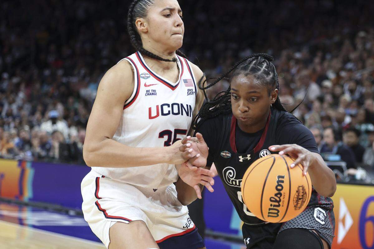 South Carolina's Ta'Niya Latson (00) drives by University of Connecticut’s Azzi Fudd (35) during the second half of action of their women's basketball game in the NCAA Tournament semifinals against UConn at Mortgage Matchup Center in Phoenix on Friday, April 3.2026. NCAA Tournament semifinals