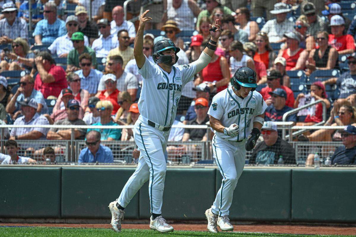 Jun 13, 2025; Omaha, Neb, USA; Coastal Carolina Chanticleers right fielder Blagen Pado (22) and first baseman Colby Thorndyke (16) celebrate after scoring against the Arizona Wildcats during the second inning at Charles Schwab Field. Mandatory Credit: Steven Branscombe-Imagn Images