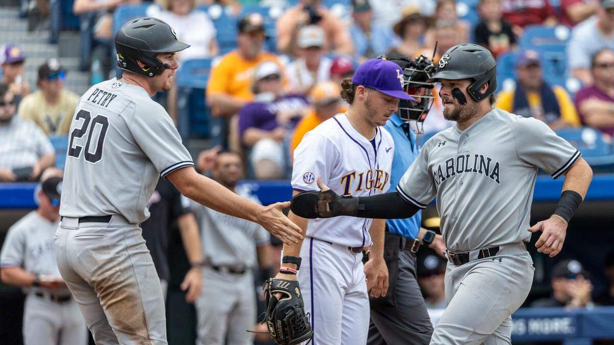 South Carolina’s Ethan Petry (20) greets catcher Cole Messina (19) after both scored on a single by infielder Parker Noland (11) during the SEC Baseball Tournament against LSU on Saturday.