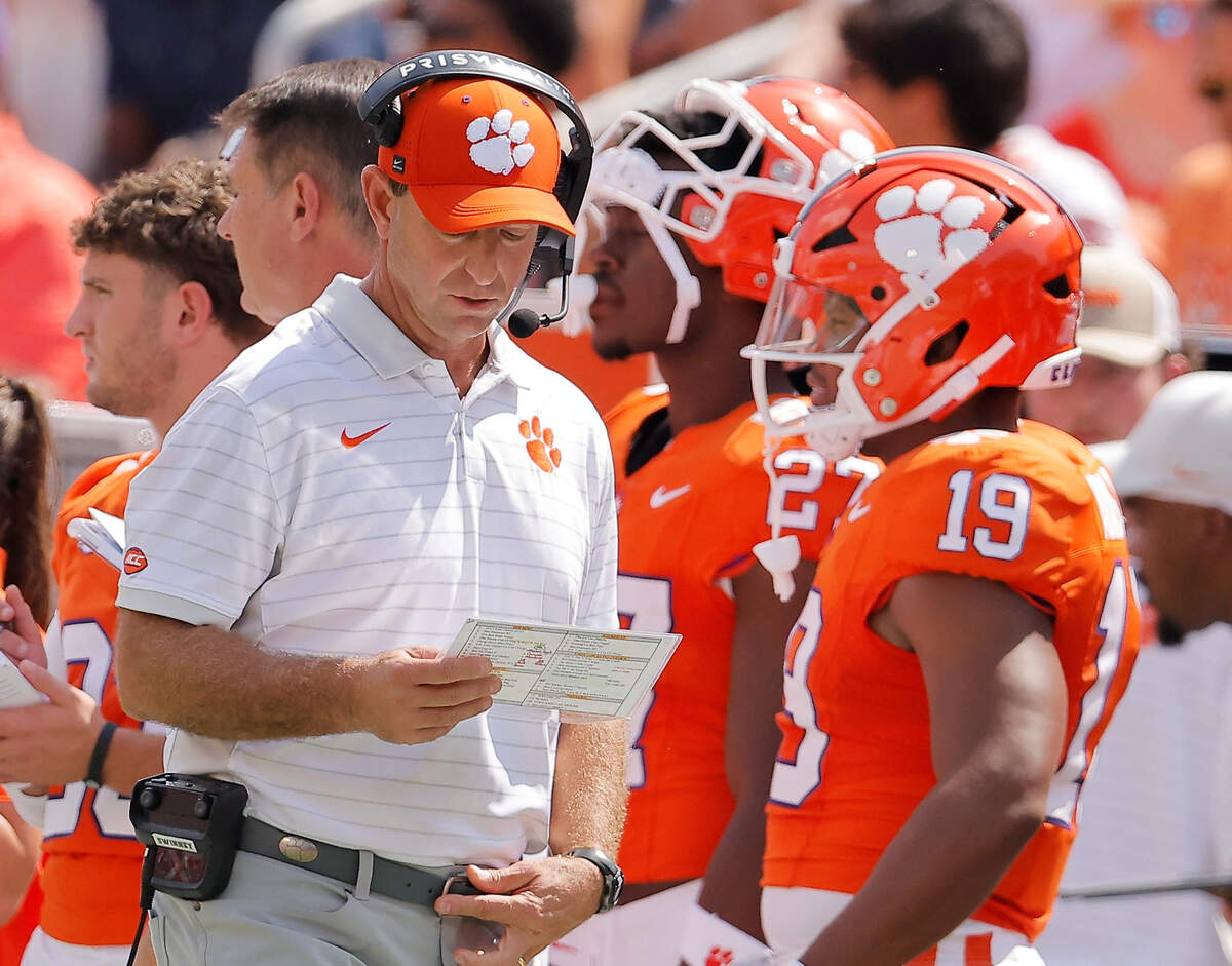 Clemson head coach Dabo Swinney looks over the playbook against Syracuse during first-half action in Clemson, S.C on Saturday, Sept. 20, 2025.