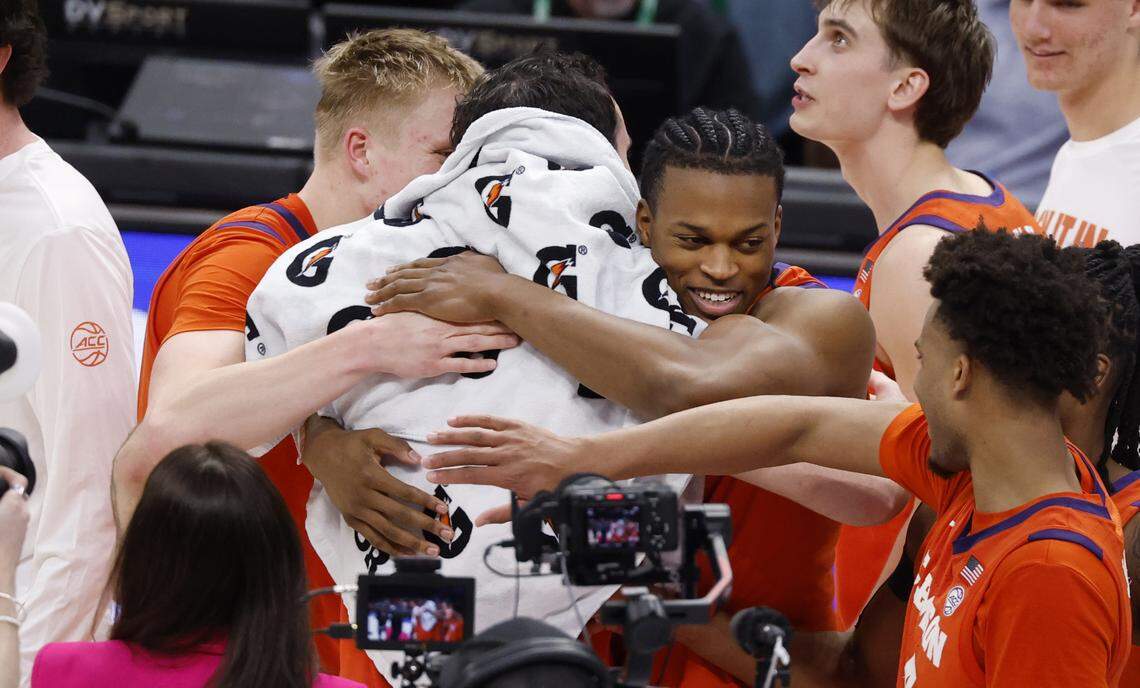 Clemson's Chase Thompson (3) and RJ Godfrey (0) hug Nick Davidson (11) after Clemson’s 80-79 victory over UNC in the quarterfinals of the 2026 ACC Men’s Basketball Tournament at the Spectrum Center in Charlotte, N.C., Thursday, March 12, 2026.