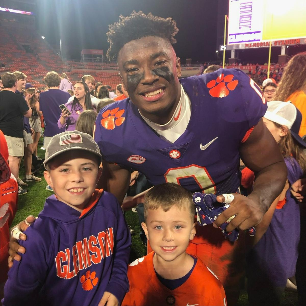 Braylen Wiley (bottom left) and Carter Wiley (bottom right) pose for a photo with Clemson linebacker Barrett Carter after a home game. Carter is one of Wiley’s favorite players on team because they share half a name.
