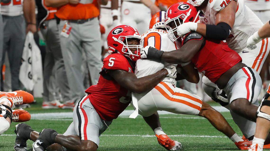 Clemson wide receiver Antonio Williams (0) is stopped by Georgia linebacker Raylen Wilson (5) and Georgia linebacker Jalon Walker (11) during the first half of the NCAA Aflac Kickoff Game against Clemson in Atlanta, on Saturday, Aug. 31, 2024.