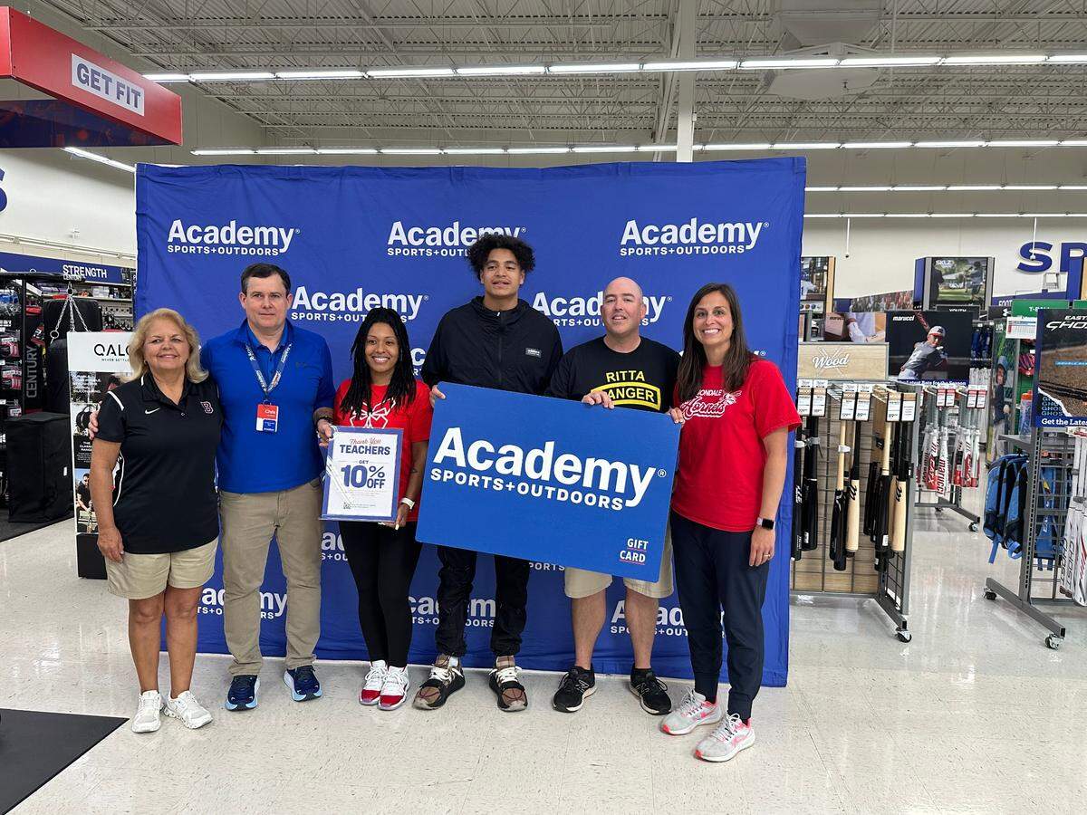 Former Dutch Fork High and University of Tennessee star football player Jalin Hyatt, center, surprises teachers with a shopping spree at Academy Sports.