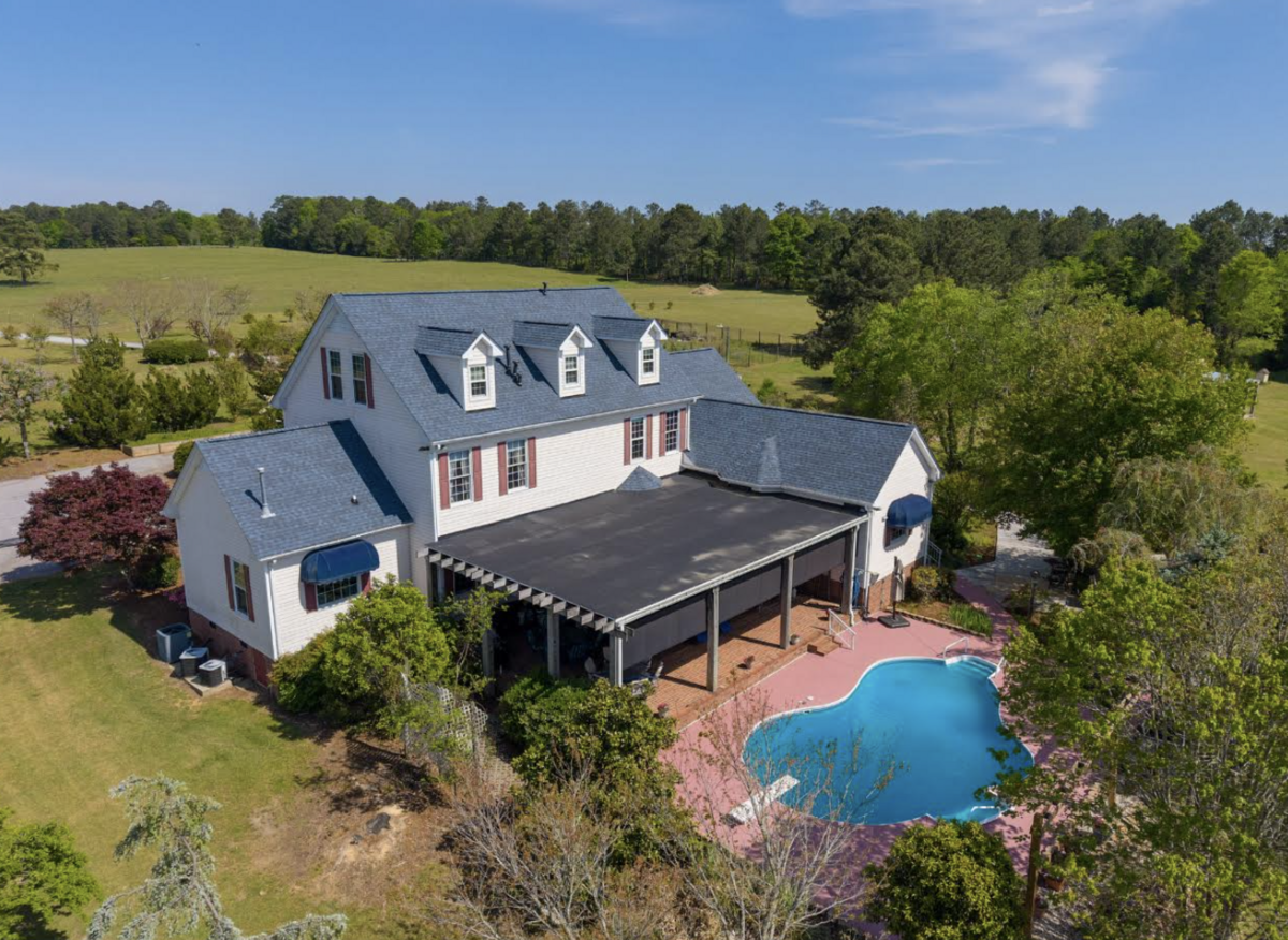Fruit trees and other plantings enhance the backyard and pool, which overlooks the lake.
