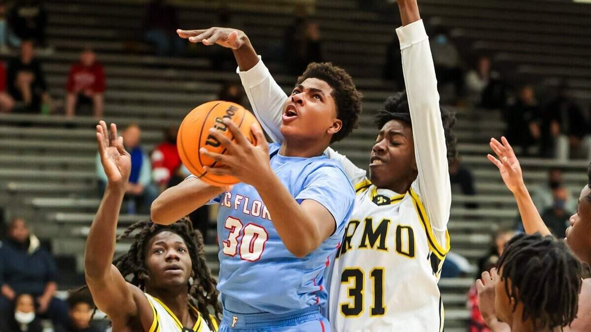 A.C. Flora Falcons Collin Murray-boyles (30) drives past Irmo Yellowjackets center Brandon Crawford (31) during their game at Irmo High School Friday evening, January 14, 2022.