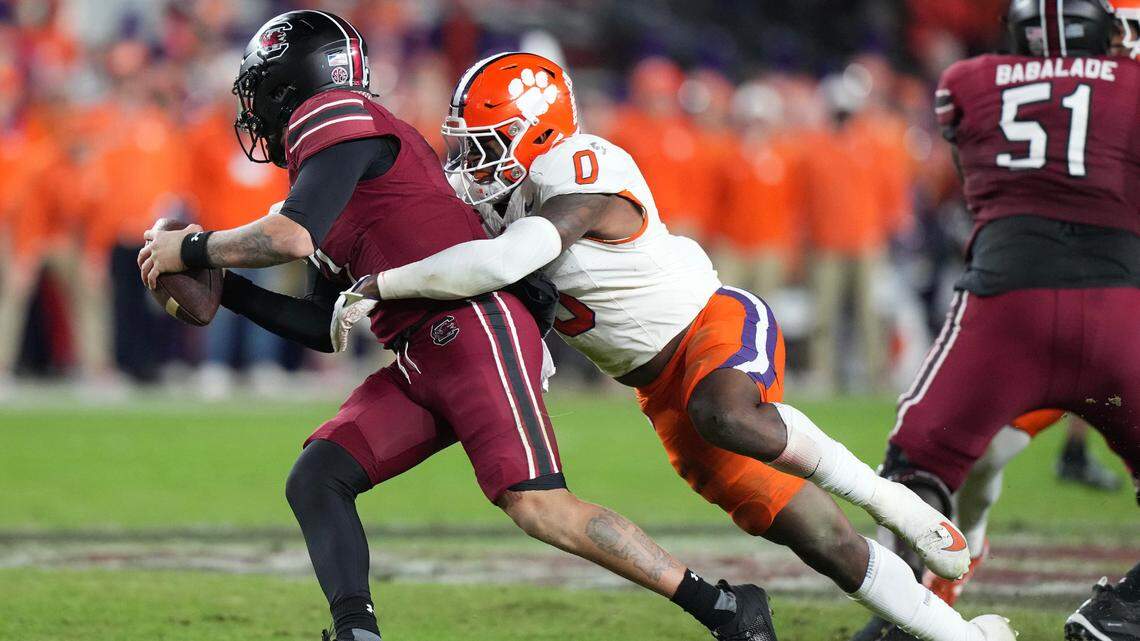 Nov 25, 2023; Columbia, South Carolina, USA; South Carolina Gamecocks quarterback Spencer Rattler (7) is sacked by Clemson Tigers linebacker Barrett Carter (0) in the first half at Williams-Brice Stadium. Mandatory Credit: David Yeazell-USA TODAY Sports