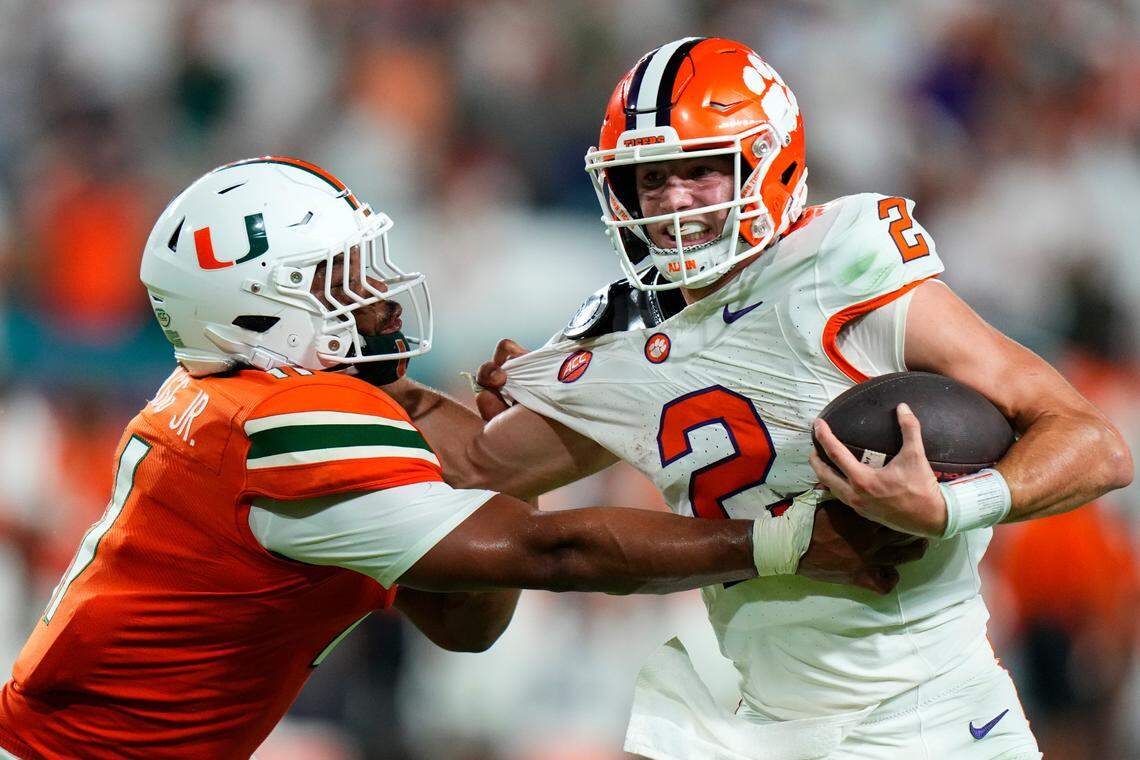 Oct 21, 2023; Miami Gardens, Florida, USA; Miami Hurricanes linebacker Corey Flagg Jr. (11) tackles Clemson Tigers quarterback Cade Klubnik (2) to win the game in over time at Hard Rock Stadium. Mandatory Credit: Rich Storry-USA TODAY Sports