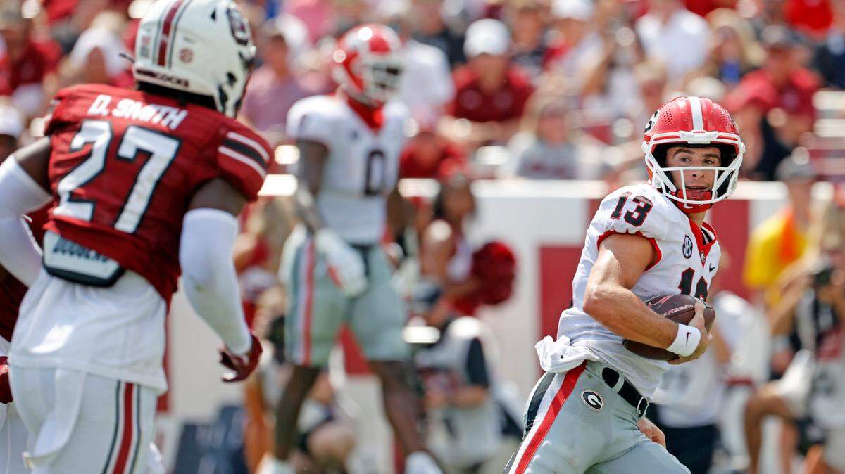 Georgia Bulldogs quarterback Stetson Bennett (13) scores a rushing touchdown and looks back at South Carolina Gamecocks defensive back DQ Smith (27) at Williams-Brice Stadium on Saturday, September 17, 2022.