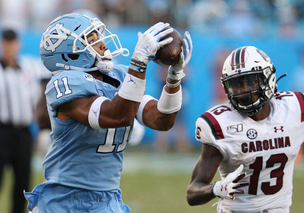 North Carolina Tar Heels defensive back Myles Wolfolk (11) intercepts the ball in front of South Carolina wide receiver Shi Smith (13) during late, fourth-quarter action in Charlotte on Saturday, Aug. 31, 2019.