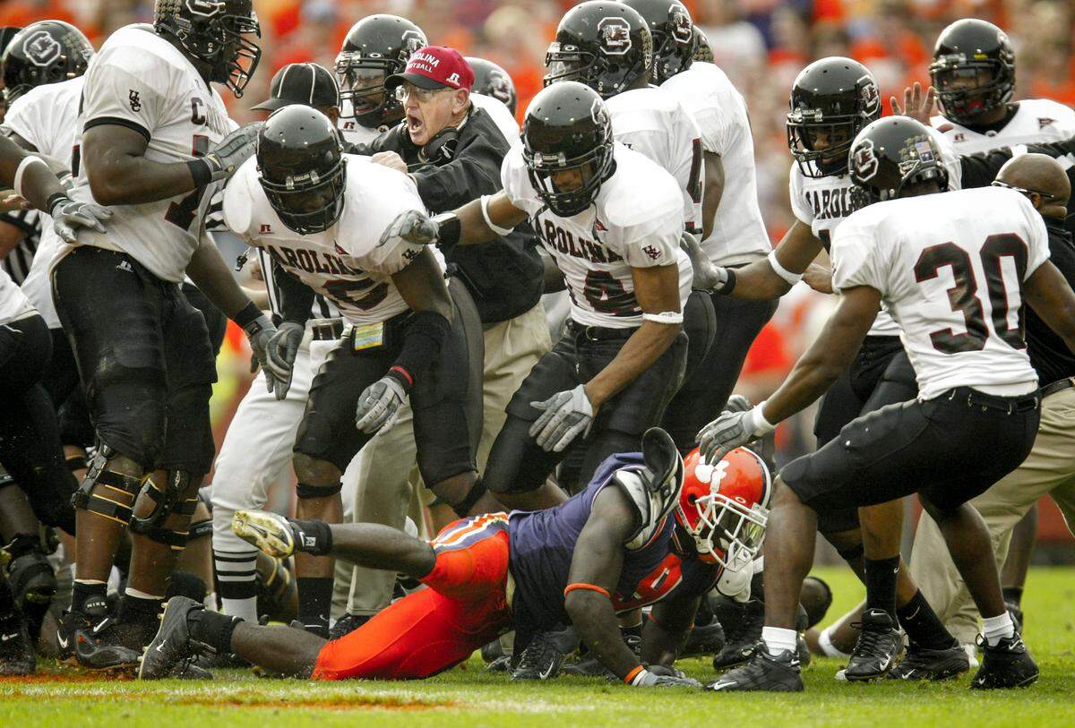South Carolina head coach Lou Holtz attempts to get control of his team during a brawl against Clemson  onSa turday, Nov. 20, 2004 in Clemson, S.C. On the ground is Clemson's Justin Miller. (Travis Bell/SIDELINE CAROLINA)
