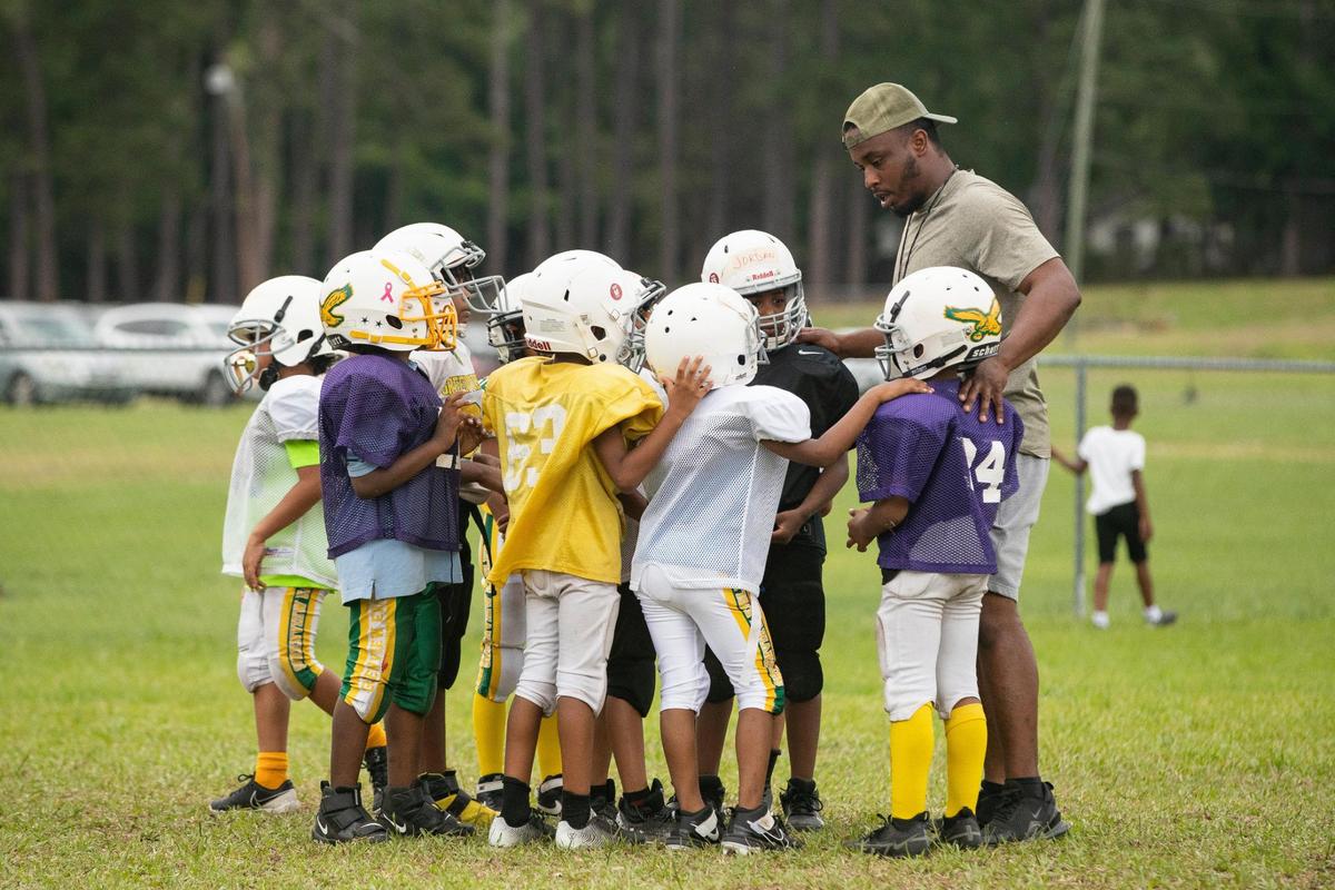 The Greenview Eagles players huddle with their coach during a practice at the former W.G. Sanders Middle School in Columbia, South Carolina on Thursday, July 7, 2022.