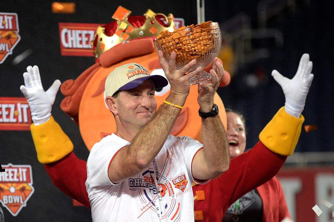 Clemson head coach Dabo Swinney holds a trophy full of crackers after winning the Cheez-It Bowl NCAA college football game against Iowa State, Wednesday, Dec. 29, 2021, in Orlando, Fla. (AP Photo/Phelan M. Ebenhack)