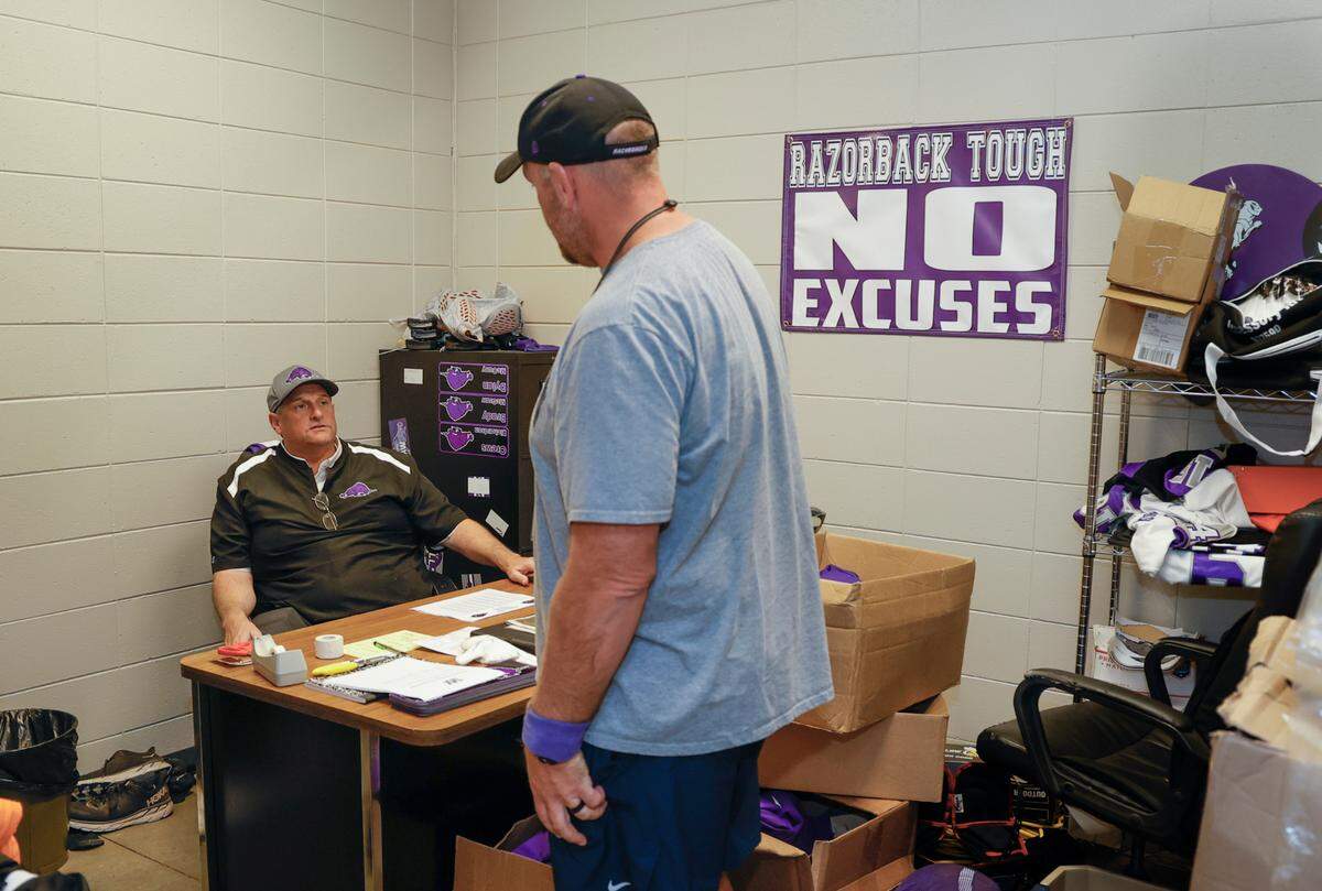 Walhalla football coach Padgett Johnson talks with JV coach Jeremy Durham at the school. Johnson has volunteered to coach the 3-A Razorback football team for the past seven seasons.