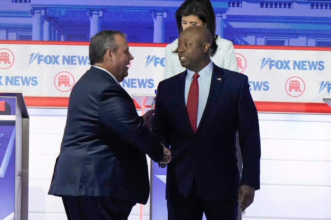 Former New Jersey Gov. Chris Christie talks with Sen. Tim Scott, R-S.C., during break at a Republican presidential primary debate hosted by FOX News Channel Wednesday, Aug. 23, 2023, in Milwaukee. (AP Photo/Morry Gash)