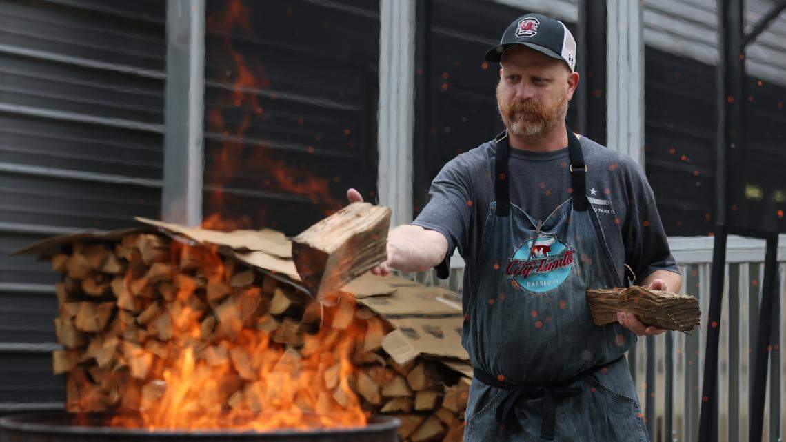 Robbie Robinson, owner of City Limits Barbeque, tosses work into a burn barrel at his West Columbia restaurant on Saturday, March 23, 2024. Robinson is a semifinalist for Best Chef in the southeast in the 2024 James Beard Foundation Awards.