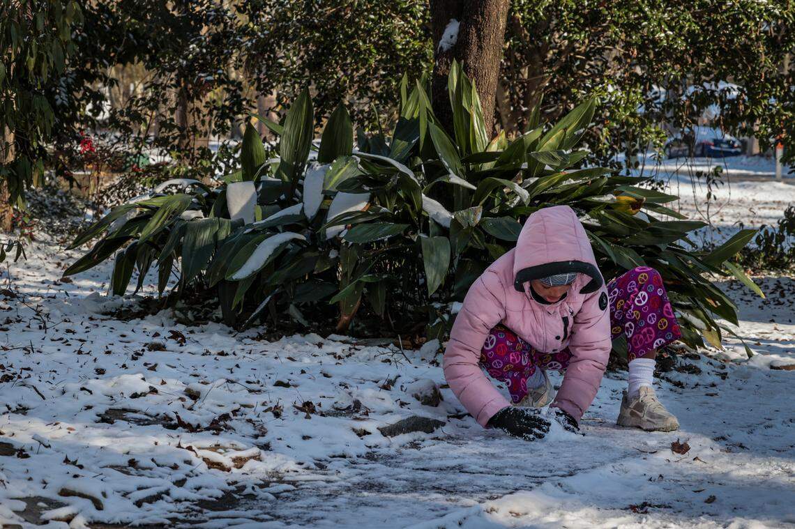 Paige Martin, 10, stacks snow to make a snow man while playing in the snow in the South Kilbourne neighborhood. on Wednesday, Jan. 22, 2025.