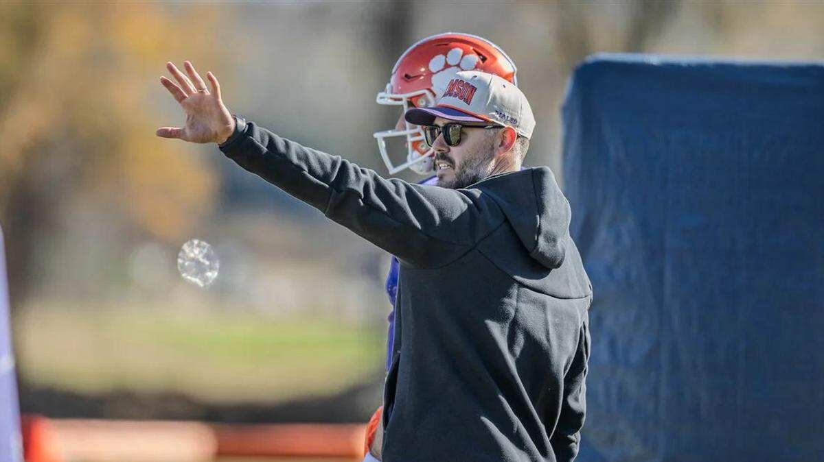 Clemson offensive coordinator Garrett Riley (foreground) and starting quarterback Cade Klubnik (background) practice on campus for the 2025 Pinstripe Bowl