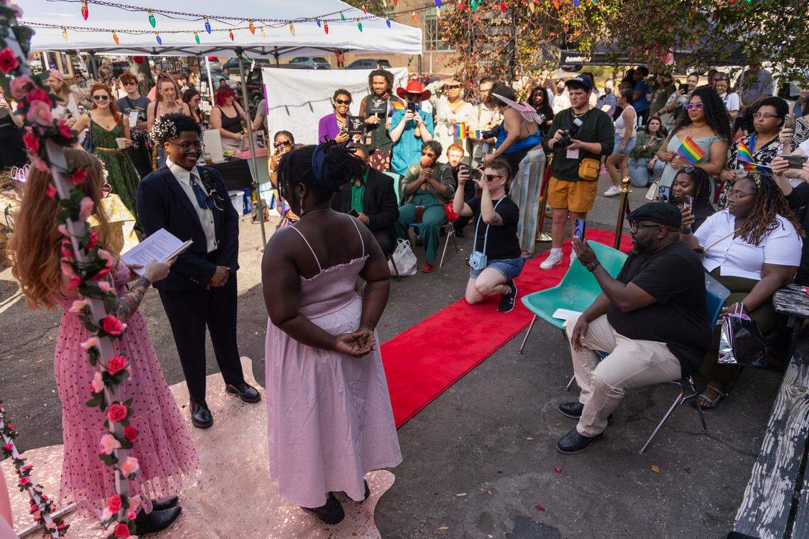 Friends, family and art market attendees watch as Mahkia Greene and Klo Hampton marry at Y’all-Mart, a quarterly art fair series, at Art Bar in Columbia, South Carolina on Sunday, February 9, 2025. Wedding officiant and Y’all-Mart cofounder spoke of the importance of love as an act of resistance in her service, and asked those in attendance to show solidarity with the newly married couples.