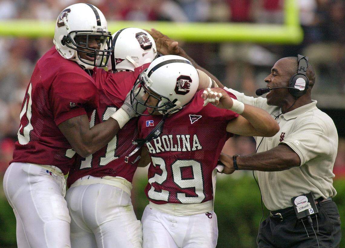 South Carolina’s Willie Offord (20), Rashad Faison (11) and Deandre Eiland (29) celebrate an interception with defensive coordinator Charlie Strong in the game where the Gamecocks upset the No. 9 ranked Georgia Bulldogs 21-10 on Sept. 9, 2000. UGA QB Quincy Carter was intercepted five times by the Gamecocks on the day.