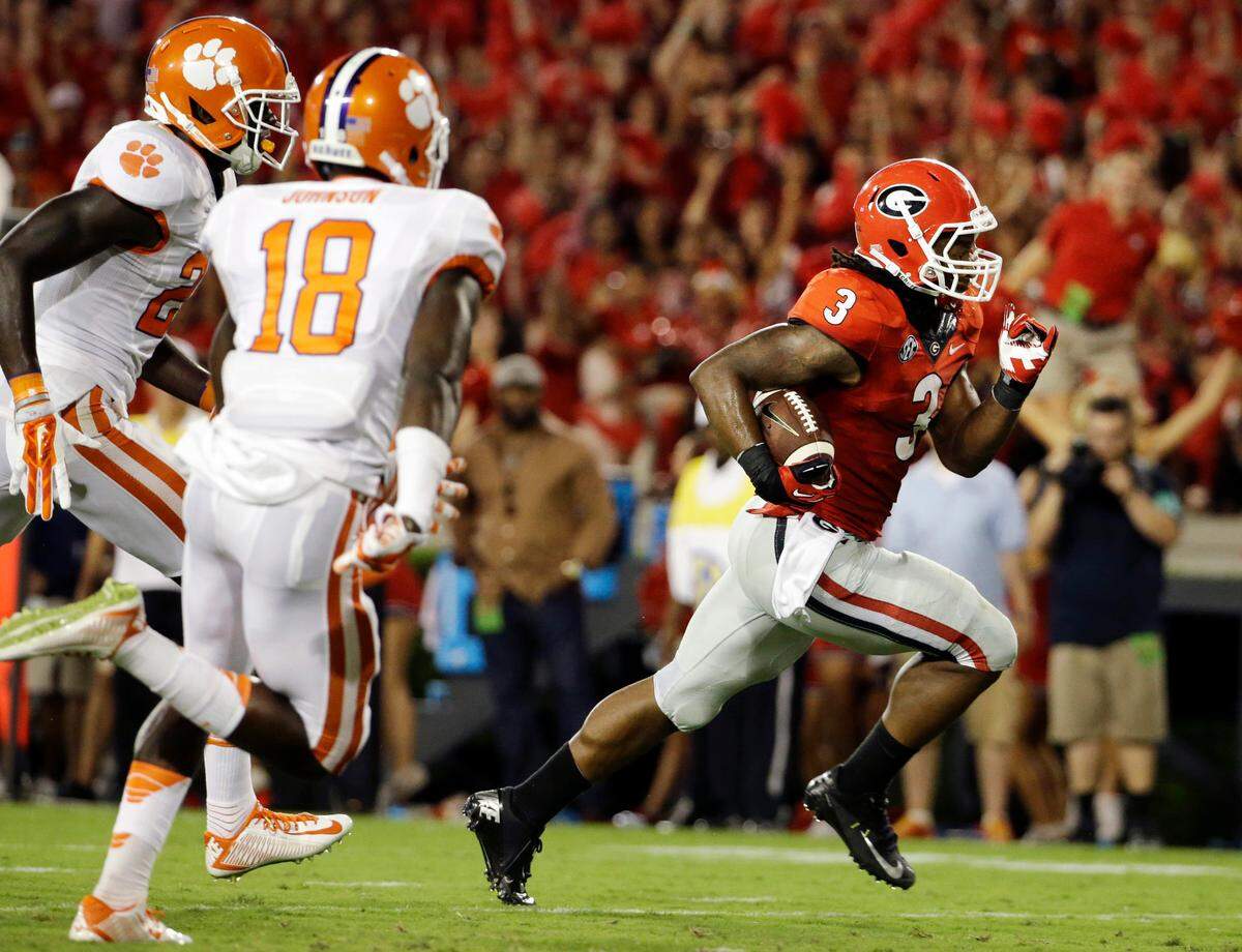 Georgia’s Todd Gurley, right, runs the ball to score a touchdown in the second half of an NCAA college football game against Clemson, Saturday, Aug. 30, 2014, in Athens, Ga. Gurley ran for 198 yards and three touchdowns, returned a kickoff 100 yards for another score, and No. 12 Georgia gained some early style points in the national race with a 45-21 victory over No. 16 Clemson on Saturday night. (AP Photo/David Goldman)