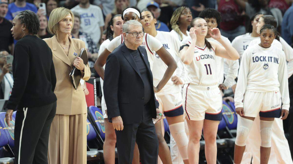 Connecticut’s head coach Geno Auriemma stands with his team after being separated after exchanging words with South Carolina's head coach Dawn Staley near the end of the game in the NCAA Tournament semifinals at Mortgage Matchup Center in Phoenix on Friday, April 3.2026.