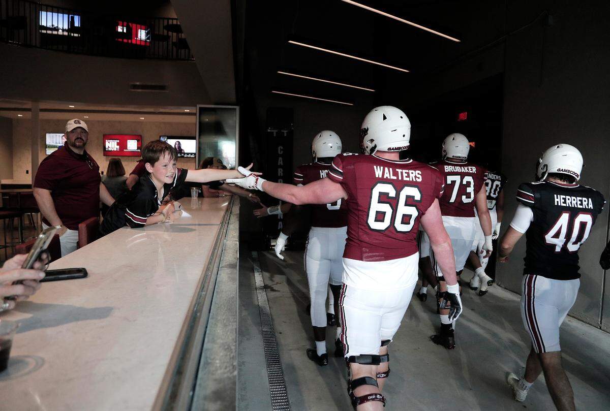 Weston Boling of Columbia reaches out for player high-fives before the 2023 spring game at Williams-Brice Stadium. Boling and his family were inside the 2001 Club before the game. The club space has an up-close view of the Gamecocks as they walk to and from the locker room.