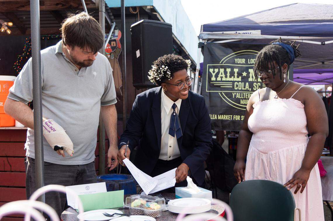Mahkia Greene and Klo Hampton sign their marriage license at Y’all-Mart, a quarterly art fair series, at Art Bar in Columbia, South Carolina on Sunday, February 9, 2025. Eight LGBT couples married for free in what organizers called a “mass gay wedding” that also raised over $3,500 for the Harriet Hancock Center’s name change fund.