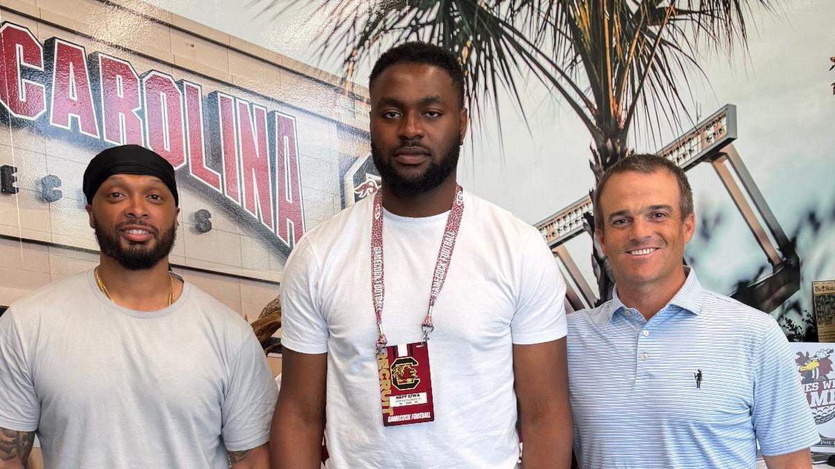 6-foot-7 Nigerian/Irish rugby player Neff Giwa (center) has committed to play college football for South Carolina and coach Shane Beamer (right)