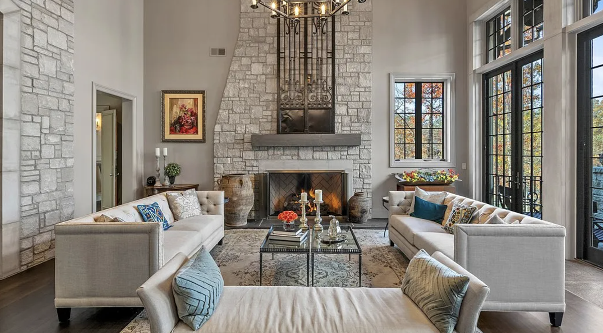 A walnut-floored great room with views of the lake and tall windows and doors has 24-foot ceilings and a cast stone fireplace.