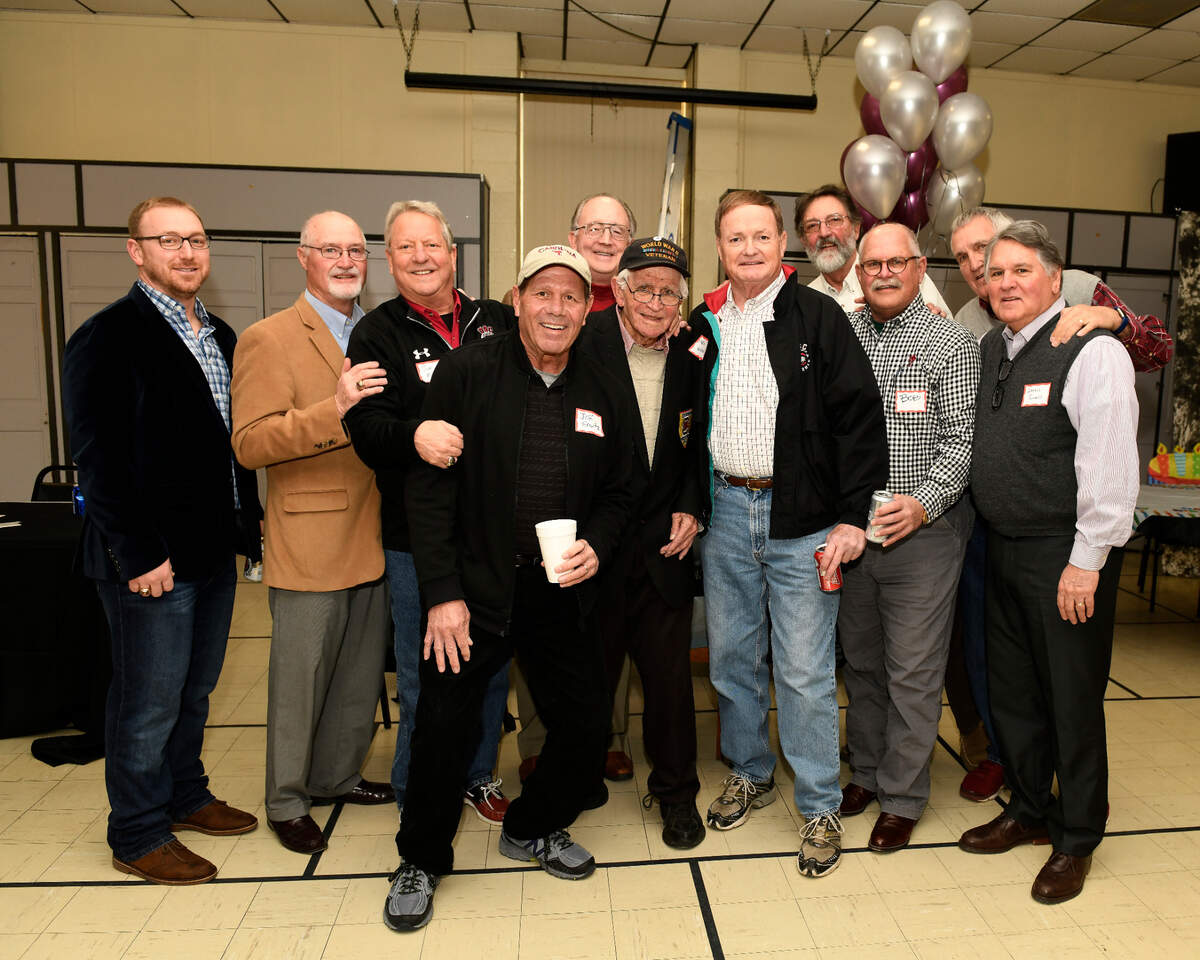 The late R.J. Moore at his 95th birthday party on Feb. 3, 2018, flanked by former University of South Carolina football players.