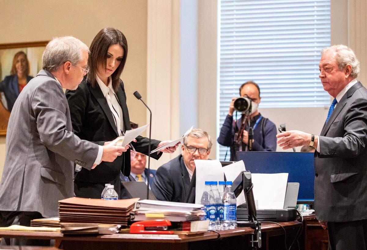 Creighton Waters (left) and Savanna Goudein are handed evidence photographs by Dick Harpootlian (right) in the double murder trial of Alex Murdaugh at the Colleton County Courthouse in Walterboro, Monday, Jan. 30, 2023. Andrew J. Whitaker/The Post and Courier/Pool