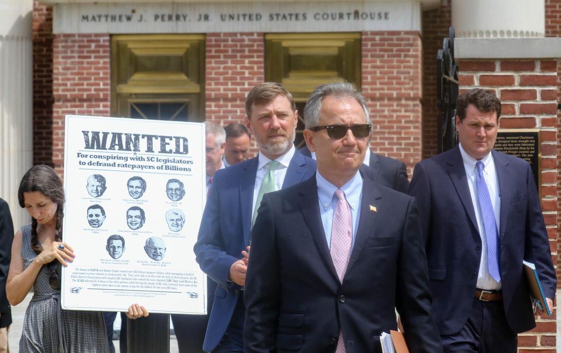 After a hearing involving a top Westinghouse executive in the ongoing SCANA debacle, acting U.S. Attorney Rhett DeHart and members of his staff walk past activist Leslie Minerd at the Matthew J. Perry federal courthouse.