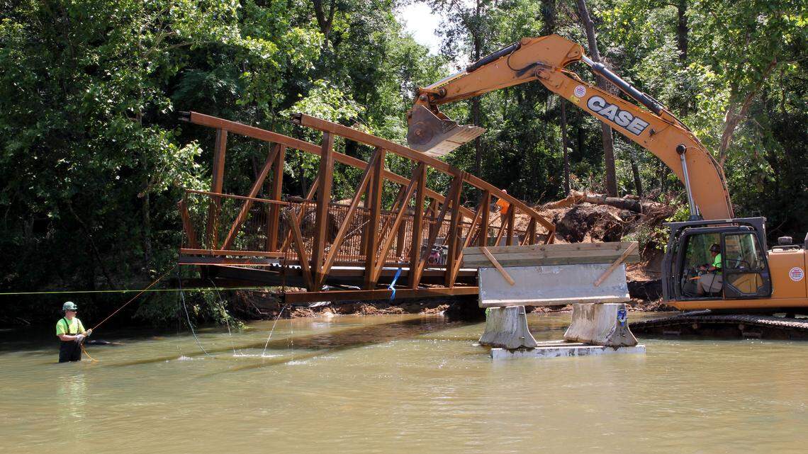 A crew installs a pedestrian bridge on the confluence of the Saluda, Broad and Congaree Rivers, Tuesday, June 19, 2018, in Columbia, South Carolina. The bridge will provide access to Boyd Island from the Three Rivers Greenway. (Ashlen Renner/The State)