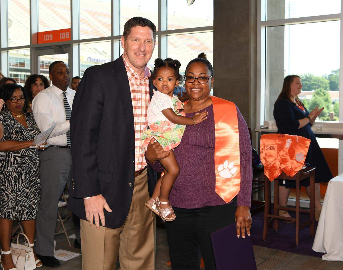 Clemson coach Brad Brownell poses for a picture with Demontiz Stitt's mom Tiffany Cornelius and daughter Deztinee Stitt.