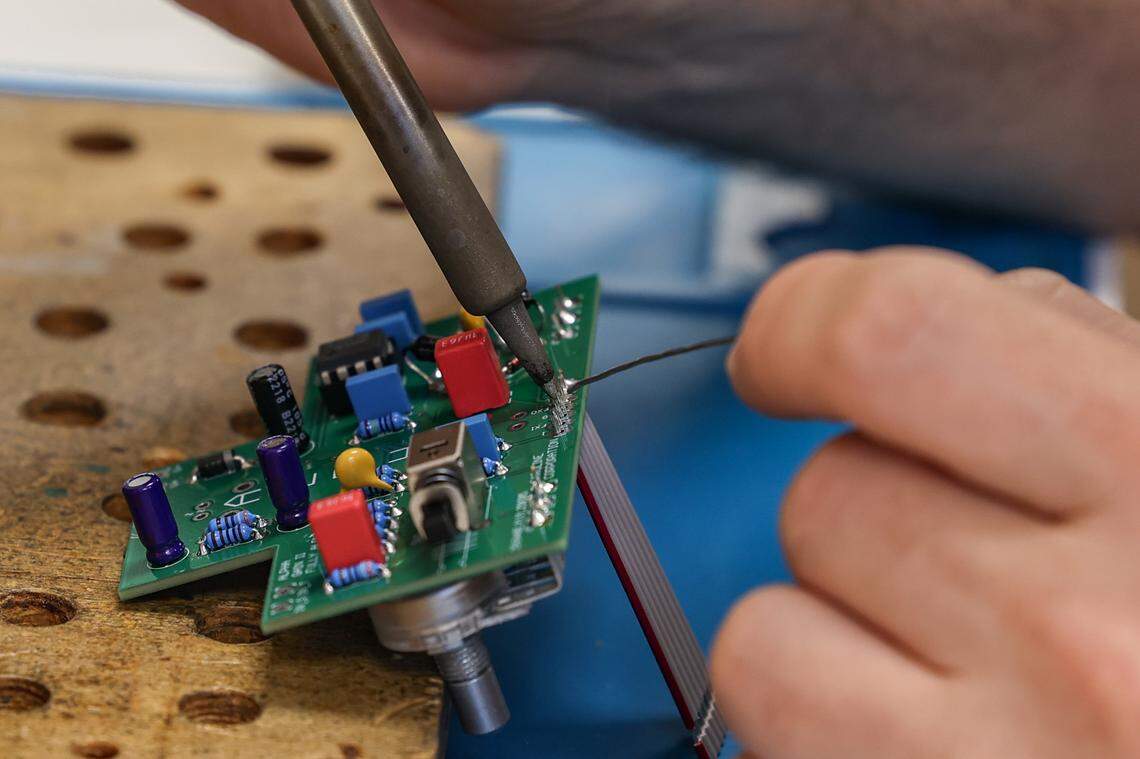 Chris Gardner assembles a guitar pedal on Wednesday, June 18, 2025 at River Drive Creative. The business houses Archer Avenue Studio and Caroline Guitar Company.