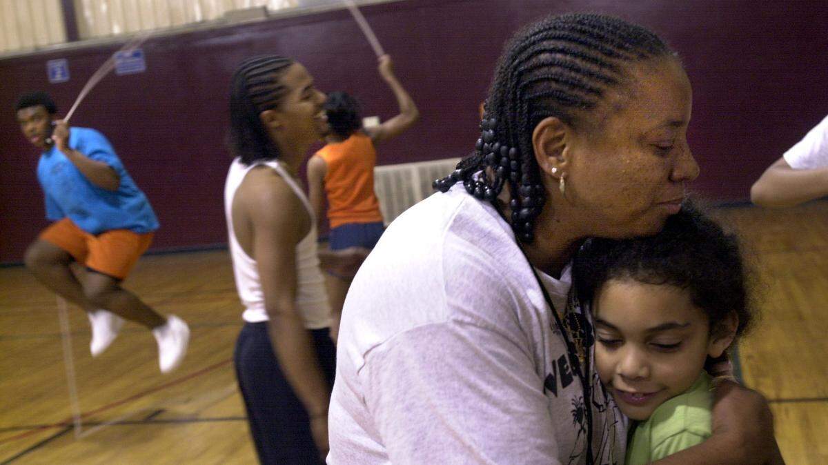 Joy Holman, who coached Columbia's Double Dutch Forces for more than 30 years, passed away on Tuesday, July 17.
Here, she gets a  spontaneous hug at the end of a
practice at Martin Luther King Park in 2003.