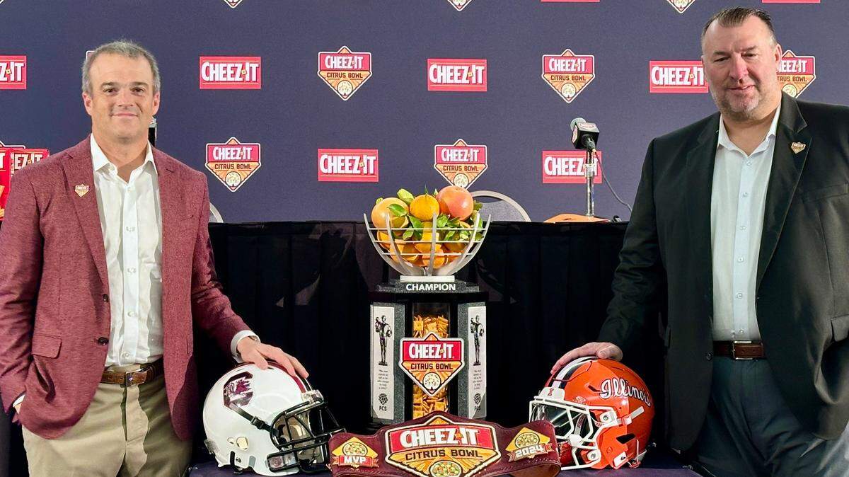 South Carolina head coach Shane Beamer (Left) and Illinois head coach Bret Bielema pose with the Cheez-It Citrus Bowl trophy on Monday.