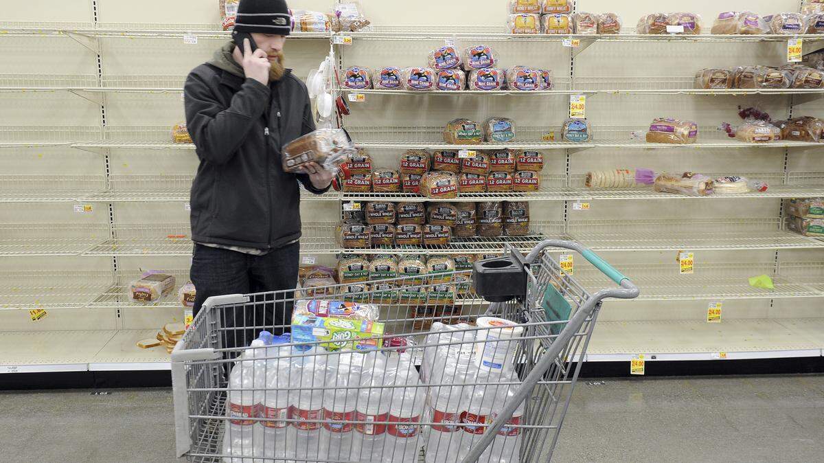 Anchorage resident C.J. Johnson stocks up on water and bread at a local grocery, after the morning’s 7.0-magnitude earthquake which caused extensive damage to the local area in Anchorage, Alaska, Friday, Nov. 30, 2018. The earthquake that shook Anchorage and damaged roadways also knocked many traffic lights out of service and has snarled traffic. (AP Photo/Michael Dinneen)