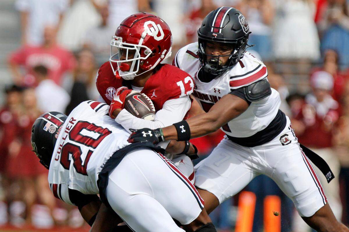 South Carolina’s Judge Collier (20) and Nick Emmanwori (7) tackle Oklahoma’s J.J. Hester (13) in the first quarter, Saturday, Oct. 19, 2024, at Gaylord Family - Oklahoma Memorial Stadium in Norman, Okla.