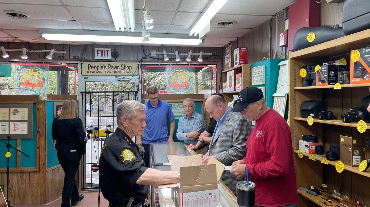 Richland County Sheriff Leon Lott hands out pamphlets about gun safety at the People’s Pawn Shop in Columbia on Wednesday, Marh 16, 2022.