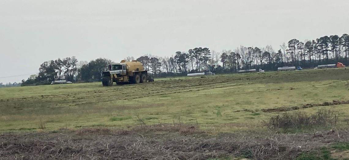 Heavy machinery spreads chicken-plant sludge on a field in Darlington County, SC. Photo taken March 2023.
